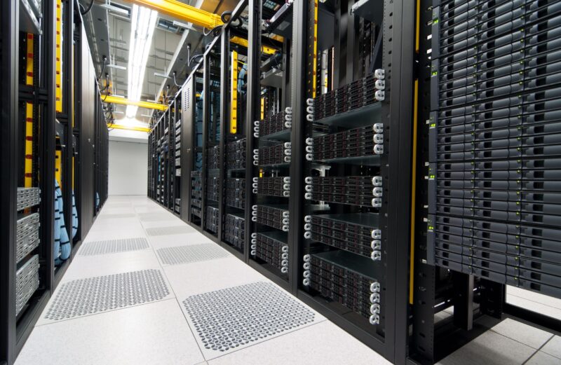 Server racks and overhead cabling. Illustrative data-center image, not a named project.